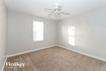 Greenfield house for rent - a bedroom with carpet and a ceiling fan