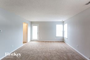 Indianapolis house for rent - A carpeted room with a door and a window.