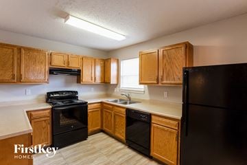 Indianapolis house for rent - A kitchen with wooden cabinets and black appliances.