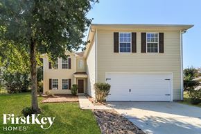 Villa Rica house for rent - a yellow house with a white garage door and a tree