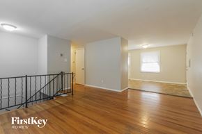 Indianapolis house for rent - the living room and dining room of an empty home with wood floors and a staircase