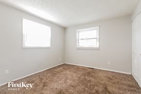 Indianapolis house for rent - a bedroom with a carpeted floor and two windows