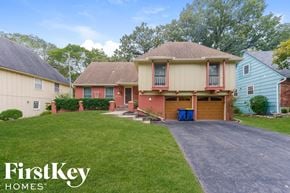 Overland Park house for rent - a home with a driveway and a lawn in front of it