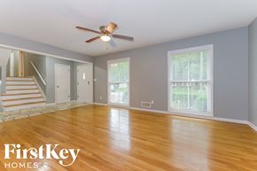 Overland Park house for rent - an empty living room with wood floors and a ceiling fan