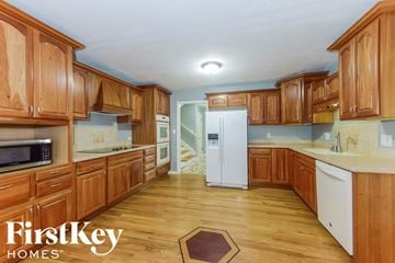 Overland Park house for rent - a kitchen with wooden cabinets and white appliances