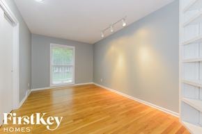 Overland Park house for rent - a bedroom with a hardwood floor and a window and white shelves