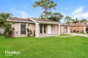 West Palm Beach house for rent - a house with a lawn and a palm tree