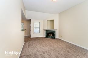 Cordova house for rent - a living room with a fireplace and a carpeted floor