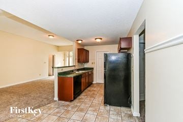 Cordova house for rent - a kitchen with a black refrigerator and a sink