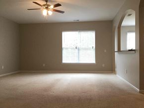 Huntersville house for rent - an empty living room with a ceiling fan and a window