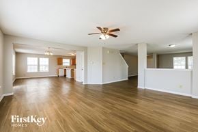 Fishers house for rent - A spacious room with wooden floors and a ceiling fan.