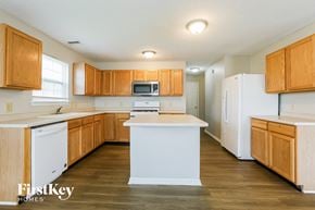 Fishers house for rent - A kitchen with wooden cabinets and a white refrigerator.