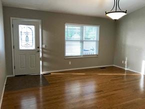 Saint Peters house for rent - an empty living room with wooden floors and a door