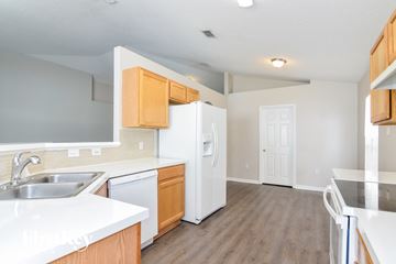 Riverview house for rent - a kitchen with white appliances and wooden cabinets and a white refrigerator