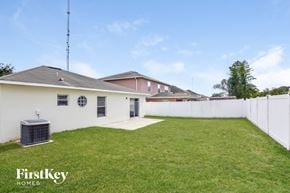 Riverview house for rent - the backyard is fenced in and has a grass lawn and a white fence