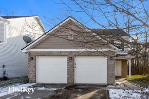 Indianapolis house for rent - a house with two white garage doors on the side of it