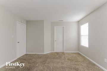 Indianapolis house for rent - a spacious living room with carpet and white walls
