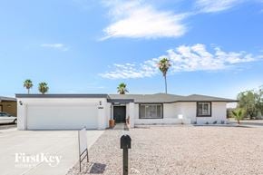 Phoenix house for rent - a white house with palm trees and a blue sky