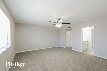 Phoenix house for rent - a spacious living room with carpet and a ceiling fan