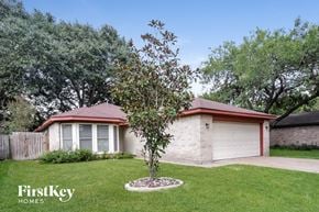 Houston house for rent - a house with a yard and a tree in front of it