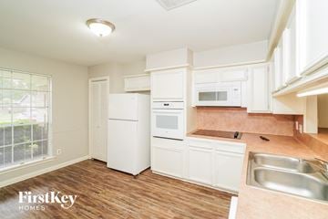 La Porte house for rent - a kitchen with white cabinets and a sink and a refrigerator