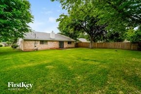 La Porte house for rent - a backyard with green grass and a brick house