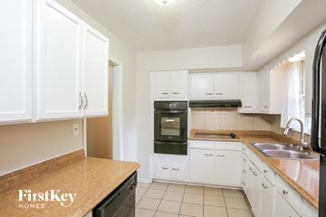 Independence house for rent - A kitchen with white cabinets and a wooden counter top.