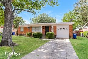Dallas house for rent - a small brick house with a white garage door