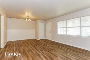 Dallas house for rent - the living room of a home with wood flooring and a large window