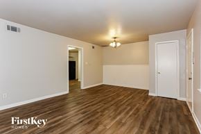 Dallas house for rent - a spacious living room with white walls and wood flooring