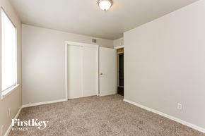 Dallas house for rent - a bedroom with white walls and carpet and a door to a closet