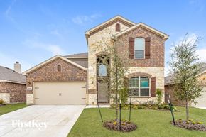 Fate house for rent - A brick house with a garage and a driveway.