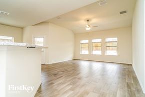 Fate house for rent - A spacious room with wooden flooring and a ceiling fan.
