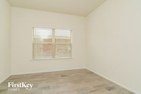 Fate house for rent - A room with a window covered in blinds and wooden flooring.