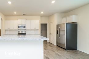 Fate house for rent - A kitchen with a white counter top and a stainless steel refrigerator.