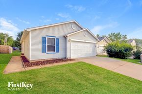 Camby house for rent - A house with a blue window and a garage door is for sale.