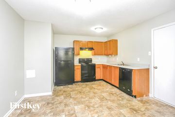 Camby house for rent - A kitchen with black appliances and wooden cabinets.