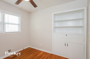 Shawnee house for rent - a bedroom with white walls and shelves and a ceiling fan