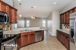 Wimauma house for rent - a kitchen with wooden cabinets and stainless steel appliances