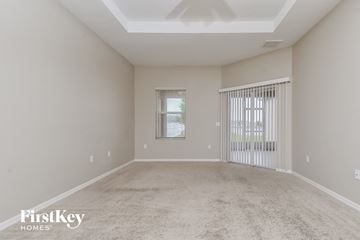 Wimauma house for rent - a spacious living room with carpet and a large window
