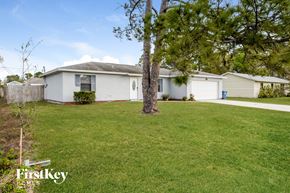 Palm Bay house for rent - a white house with a yard and a tree