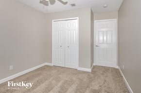 Port St. Lucie house for rent - a bedroom with two white doors and a carpeted floor