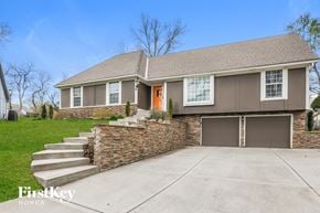 Overland Park house for rent - front view of a home with stairs to the driveway and a garage door