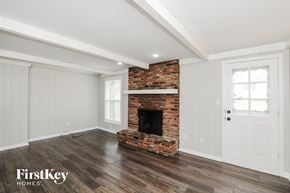 Overland Park house for rent - a living room with a brick fireplace and wooden floors