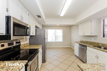 Phoenix house for rent - A kitchen with granite countertops and white cabinets.