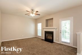 Cornelius house for rent - an empty living room with a fireplace and a ceiling fan