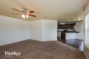 Fort Worth house for rent - A spacious living room with a carpeted floor and a ceiling fan.