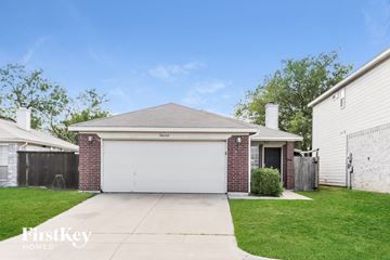 Fort Worth house for rent - a brick house with a white garage door and a lawn
