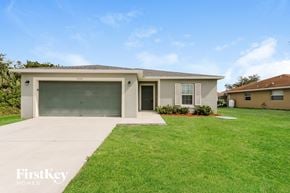 Port St. Lucie house for rent - a beige house with a driveway and a garage door