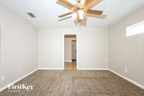 Port St. Lucie house for rent - a spacious living room with white walls and a ceiling fan